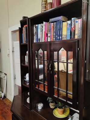 Een houten boekenkast met meerdere planken vol boeken.