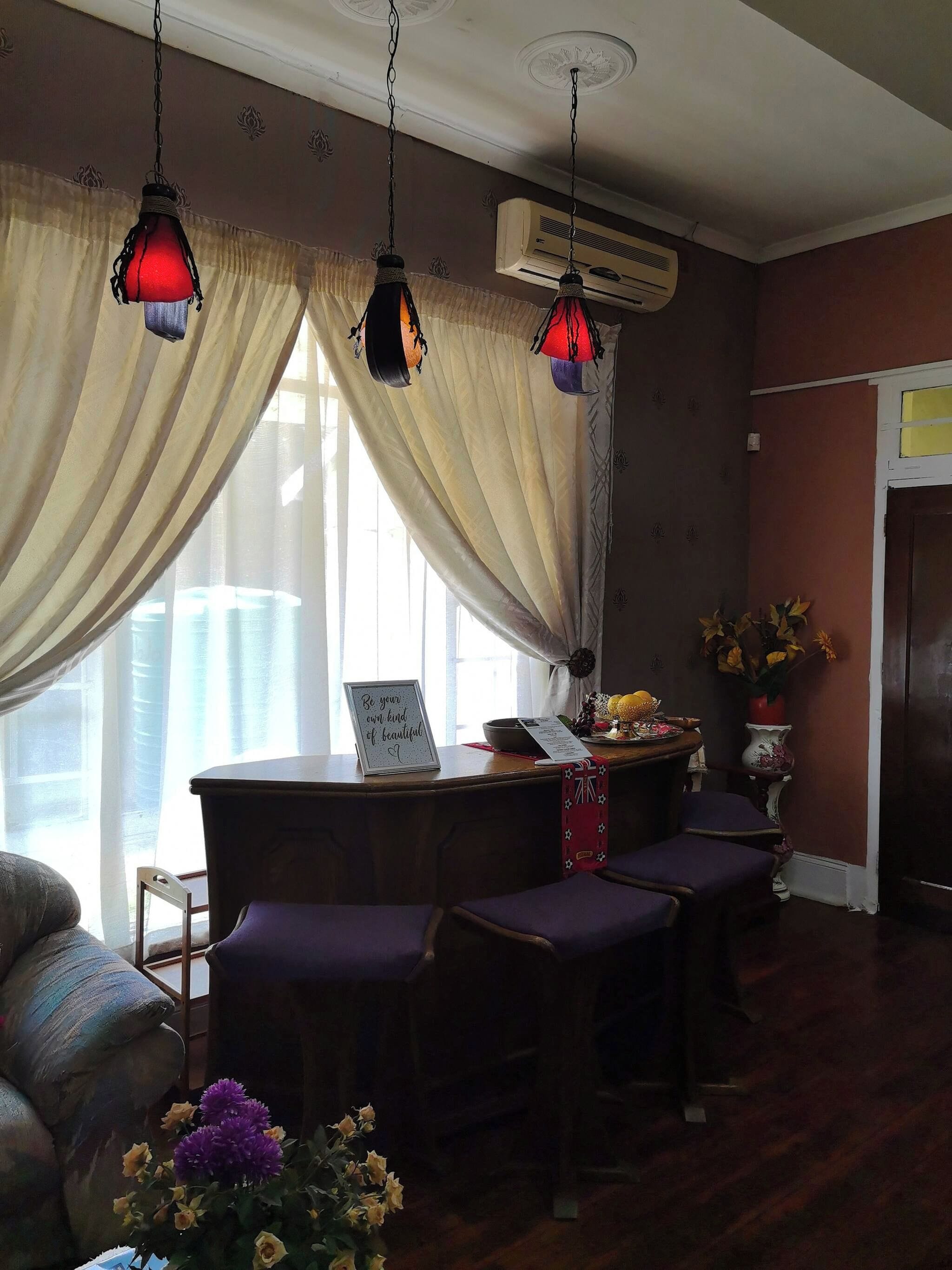 A room with a dining table, purple chairs, a decorative vase, and an air conditioning unit.