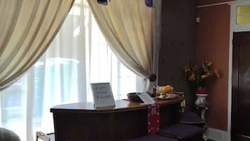 A room with a dining table, purple chairs, a decorative vase, and an air conditioning unit.