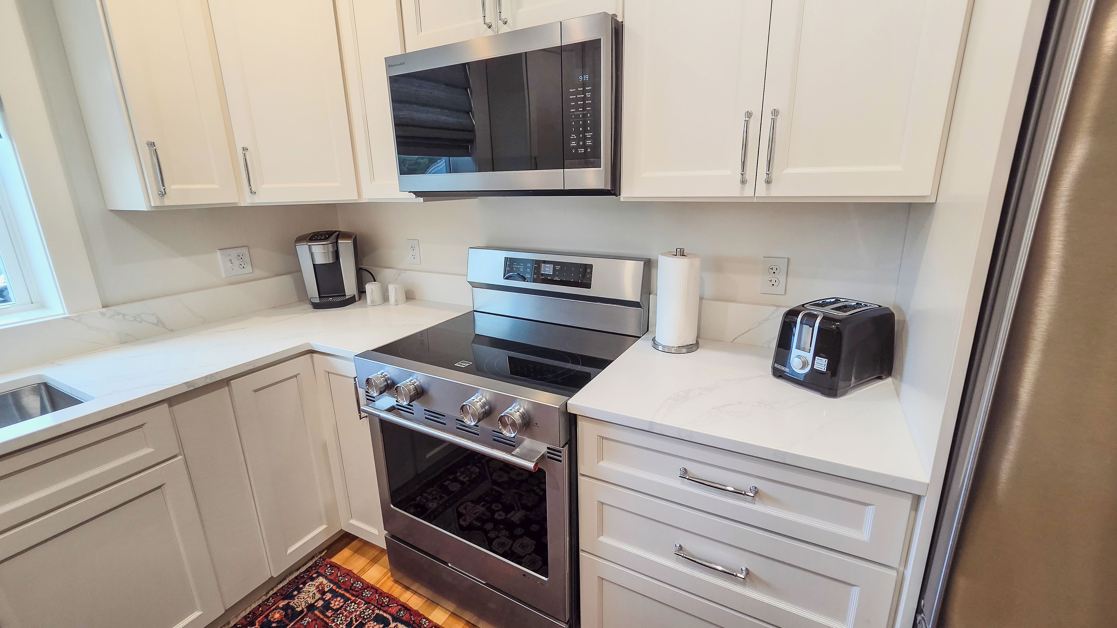 A modern kitchen with stainless steel appliances, a built-in microwave, and a toaster.
