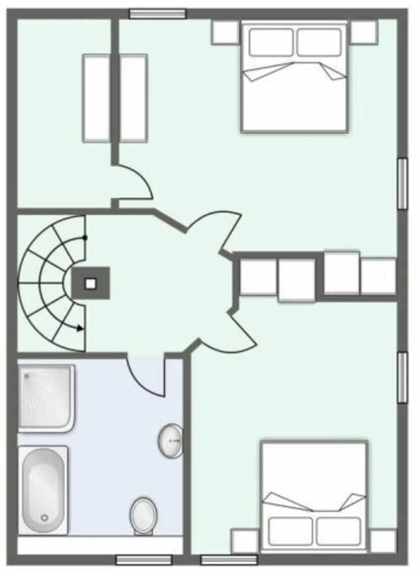 A hotel room layout with a bathroom, a kitchenette, a bed, and a seating area.