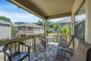 A covered outdoor area with a patio, chairs, and a star-patterned floor. - Guest Cottage 61- 4BR House- Community Pool (Myrtle Beach)
