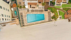 An aerial view of a property with a swimming pool, a covered patio area, and surrounding greenery. - 2BR/2BA Oceanfront- Pool- Brigadune I 11D (Myrtle Beach)