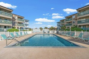 A swimming pool with lounge chairs and a '3FT NO DIVING' sign, surrounded by multi-story buildings with balconies. - A Place At The Beach III 1C- Shore Drive 2BR/2BA (Myrtle Beach)