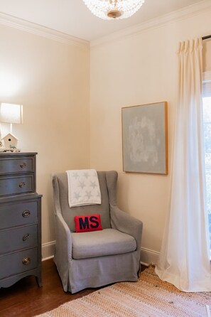 A room with a grey armchair, a wooden dresser, a lamp, a framed abstract painting, and a window with curtains. - Peaceful Home Just 10 Minutes from Oxford Square (Oxford)