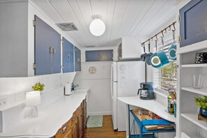 Galley kitchenette with a full-size fridge and drip coffee maker, plus a starter supply of coffee for day one. - 1BR · Sleeps 3 · Dog-Friendly · Shared Hot Tub (Saint Augustine)