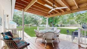 A covered outdoor patio with wicker furniture, a table, and a ceiling fan. - The Ocean Rancher - 40 Woodland Ave (Ocean View)