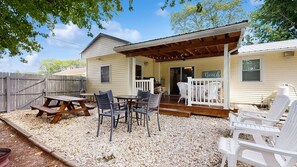 A covered patio with a table and chairs, a wooden deck, and a fenced backyard. - The Ocean Rancher - 40 Woodland Ave (Ocean View)
