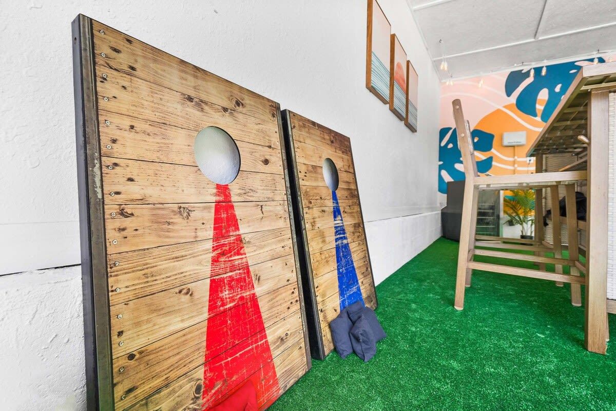 Un couloir avec des portes en bois, une moquette verte et une chaise en bois.