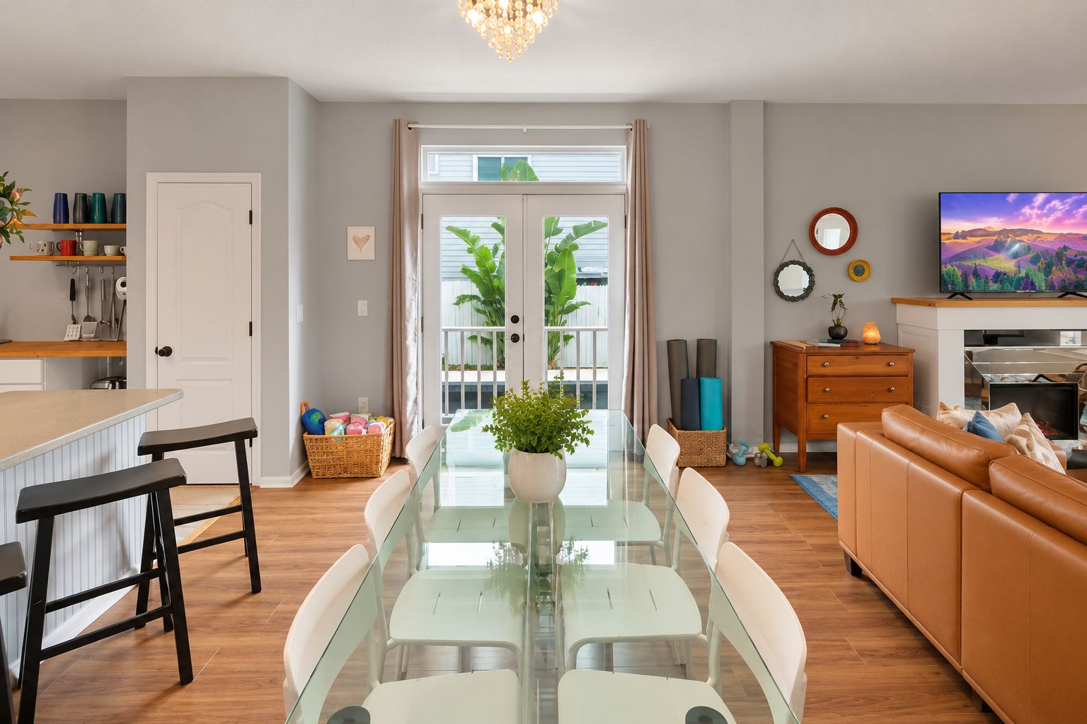 Un espace de vie moderne comprenant une table à manger en verre, un canapé et un téléviseur.