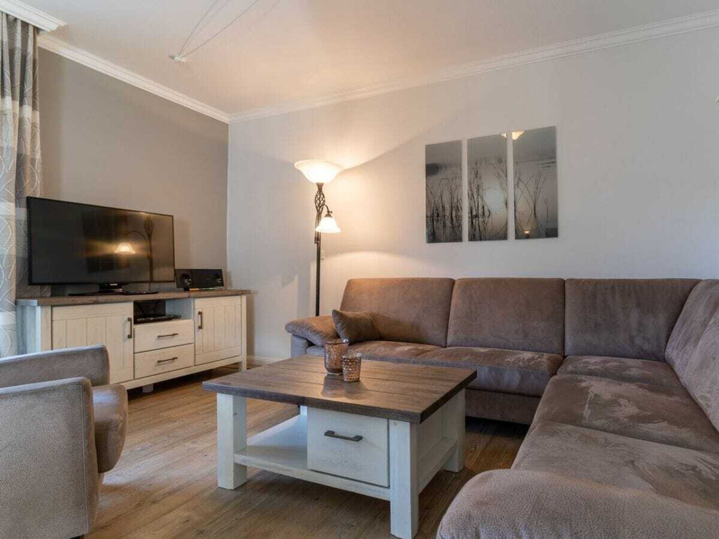 A living room with a sofa, a coffee table, a TV, and a lamp.
