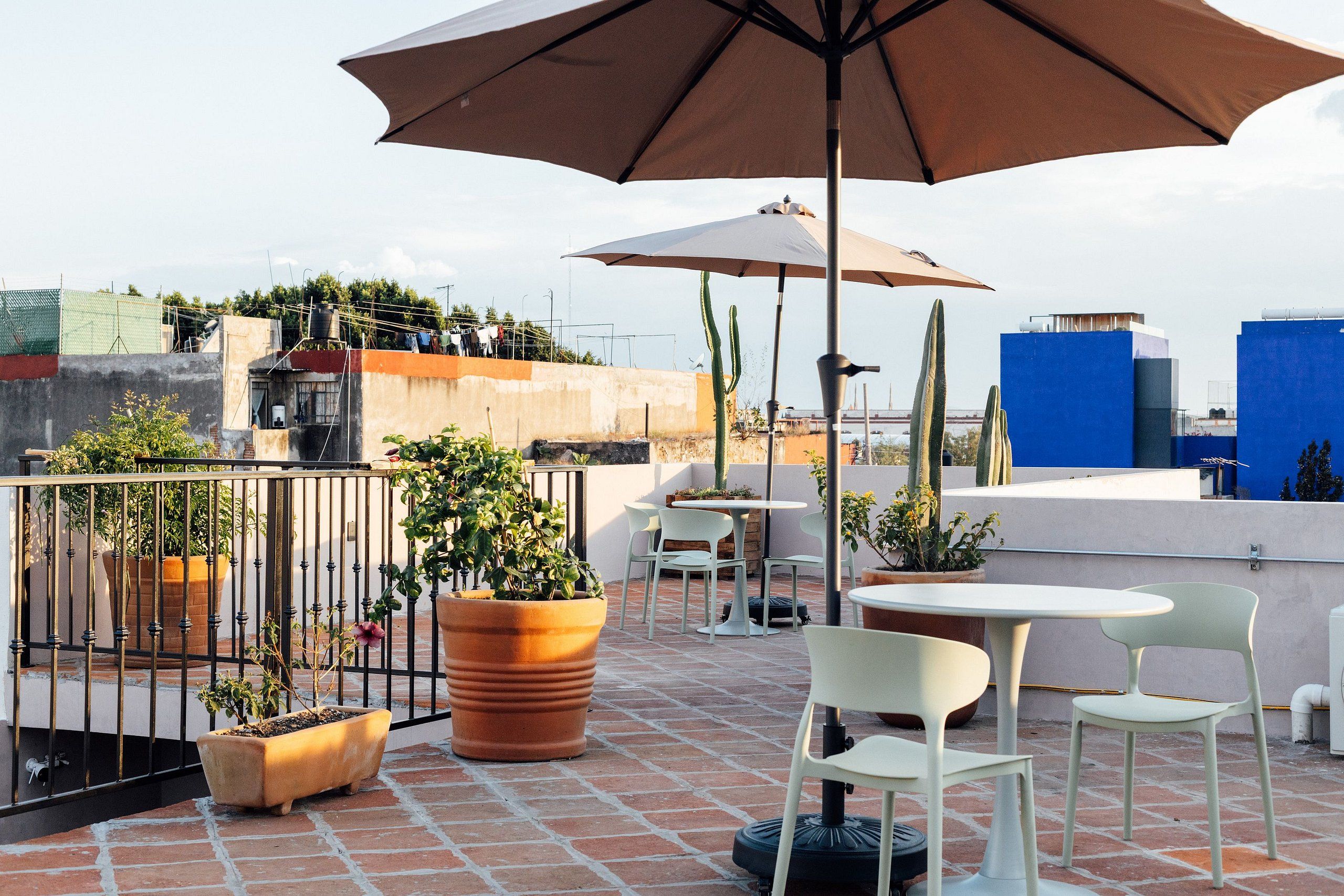 An outdoor patio area with seating, potted plants, and umbrellas.