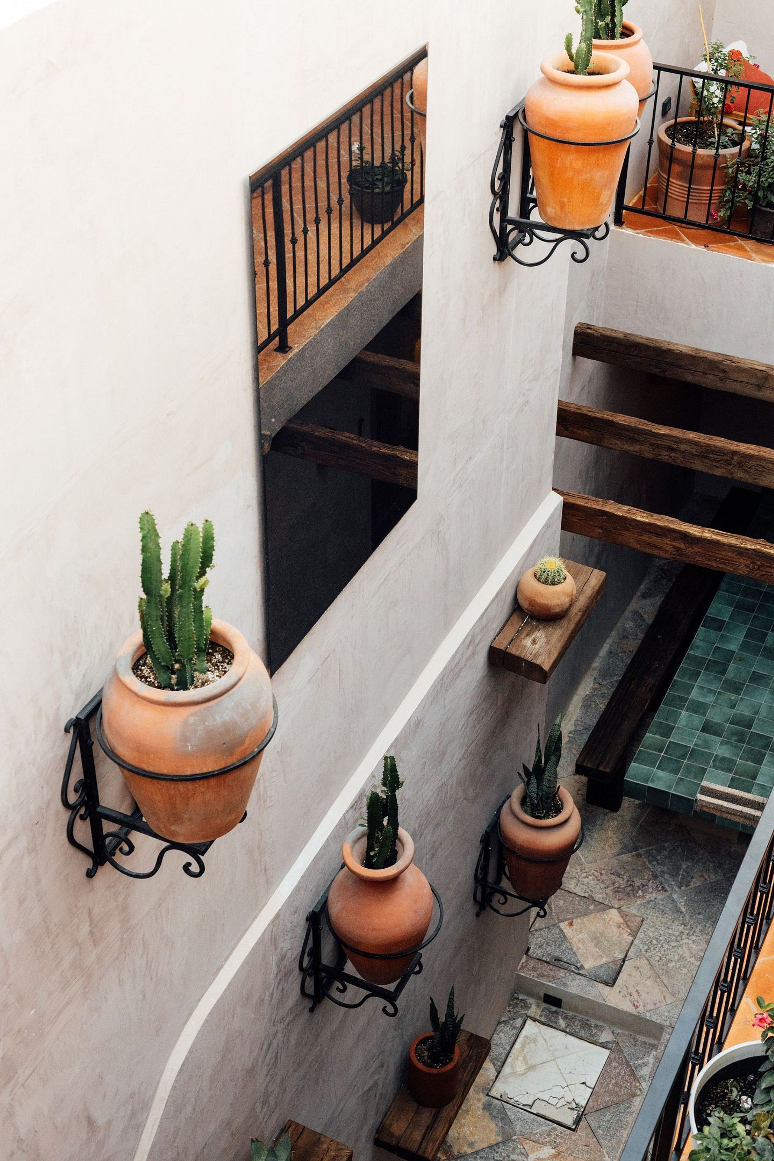 A multi-level outdoor terrace with terracotta planters and a metal railing.