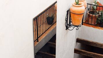 A multi-level outdoor terrace with terracotta planters and a metal railing.