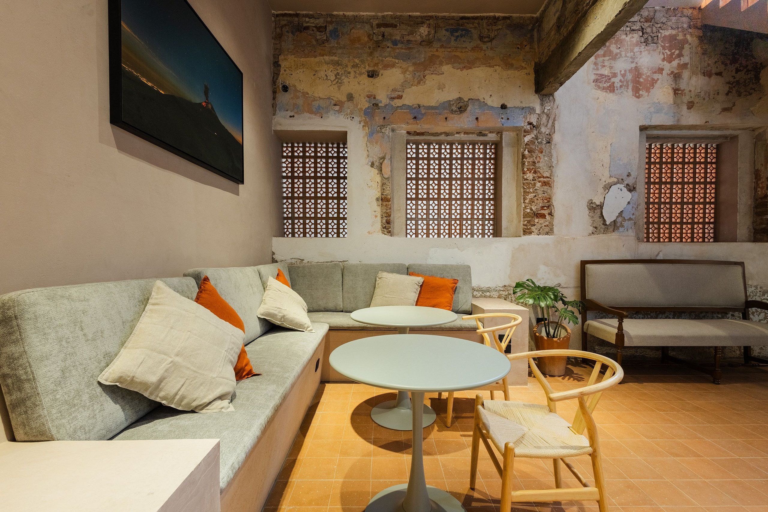 Uma sala de estar mobiliada com sofá, mesa redonda e duas cadeiras.