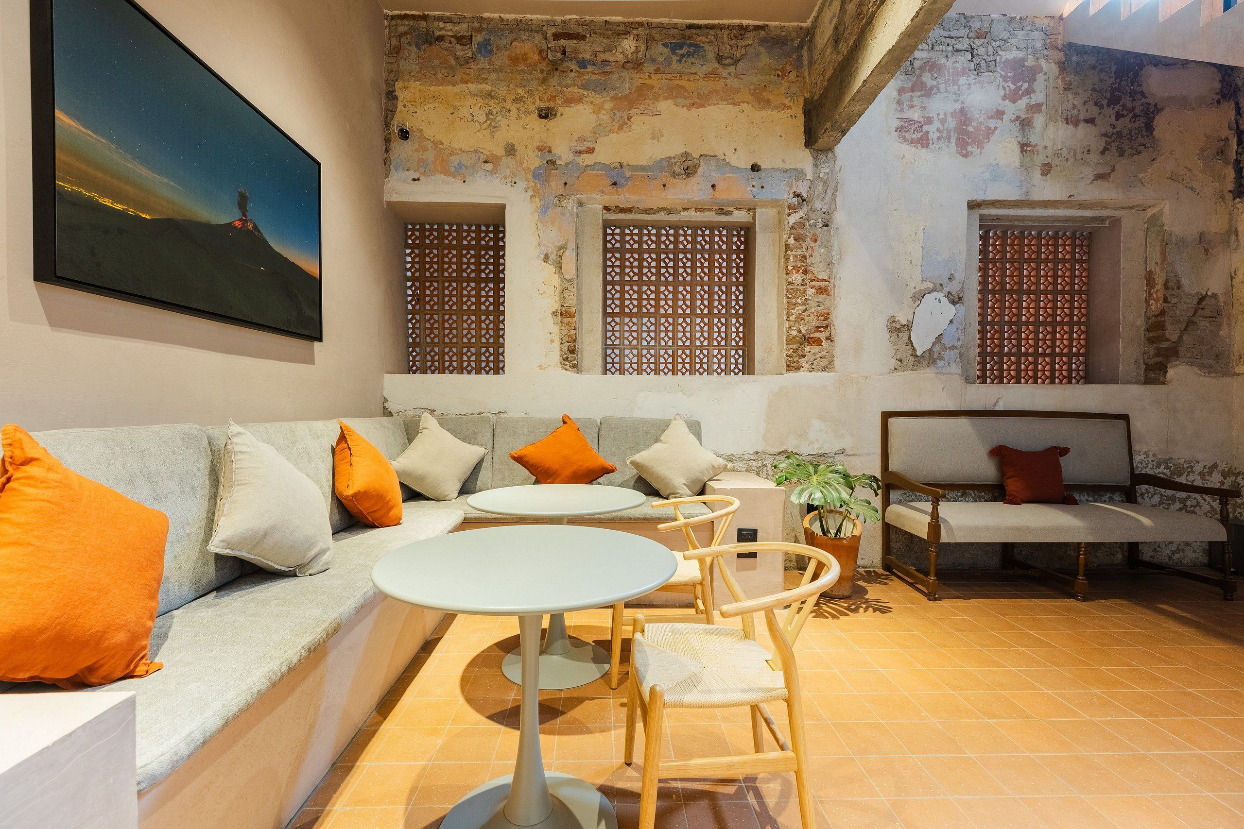 A cozy interior with a sofa, two round tables, and a bench.