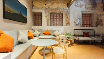 A cozy interior with a sofa, two round tables, and a bench.