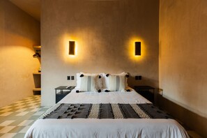 A hotel room with a large bed, two bedside tables, a checkered floor, and wall-mounted lighting. - Boutique Loft Zenit | Air Conditioning and Rooftop (Puebla)