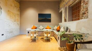 A cozy living area with a sofa, two chairs, a table, and a potted plant.