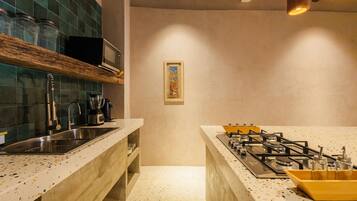 A kitchen with a gas stove, a sink, and a microwave.