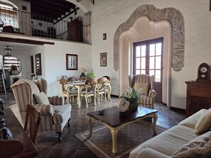 A spacious living room with a high ceiling, a dining area with a table and chairs, and a staircase leading to an upper level. - Casa La Virgen | Washing machine + Parking (Heroica Puebla de Zaragoza)