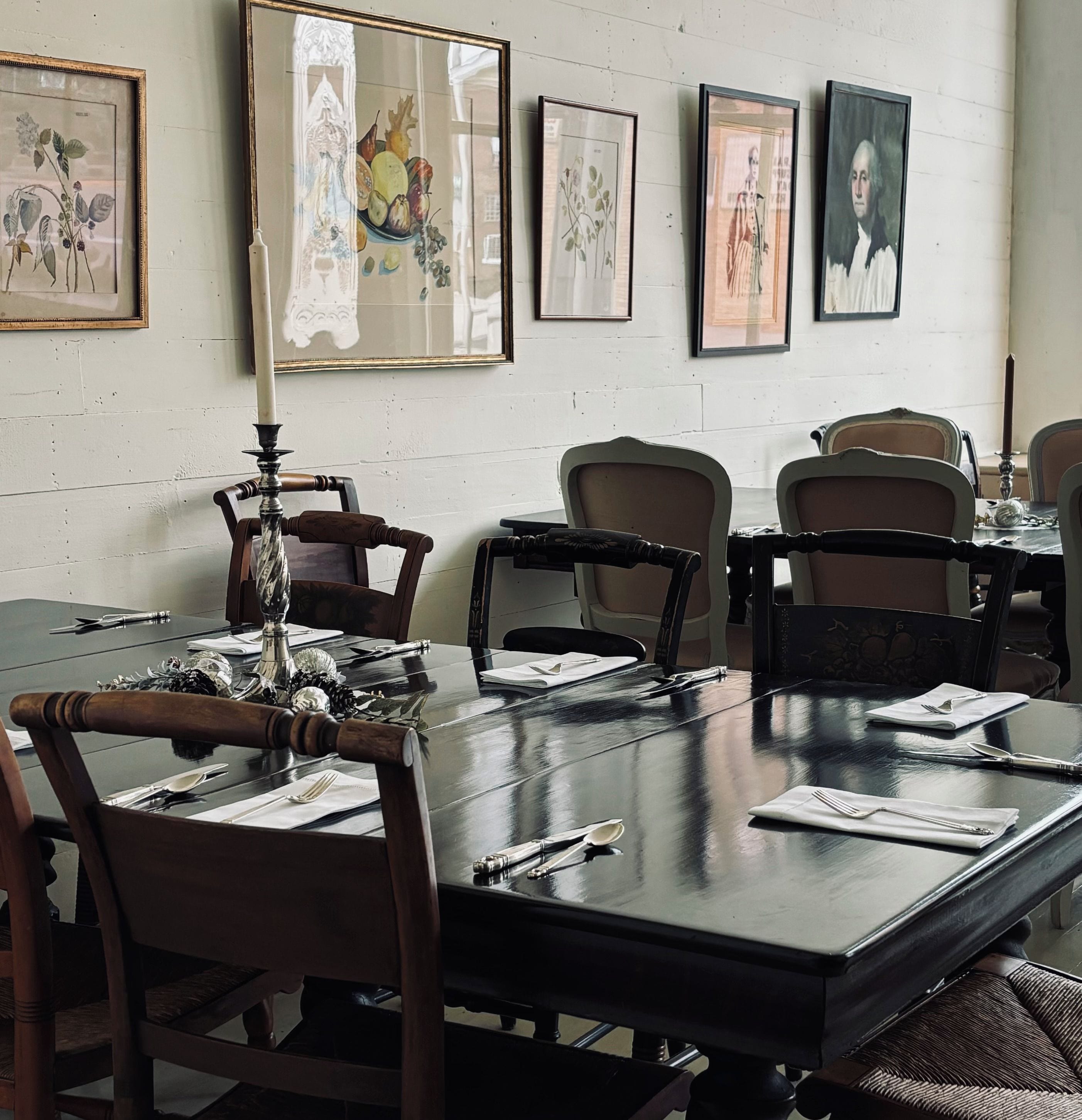 A conference room with a long table, chairs, and framed botanical prints on the wall.