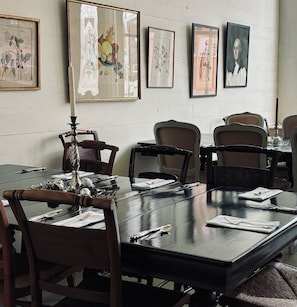 Uma sala de conferências com uma mesa comprida, cadeiras e impressões botânicas emolduradas na parede.