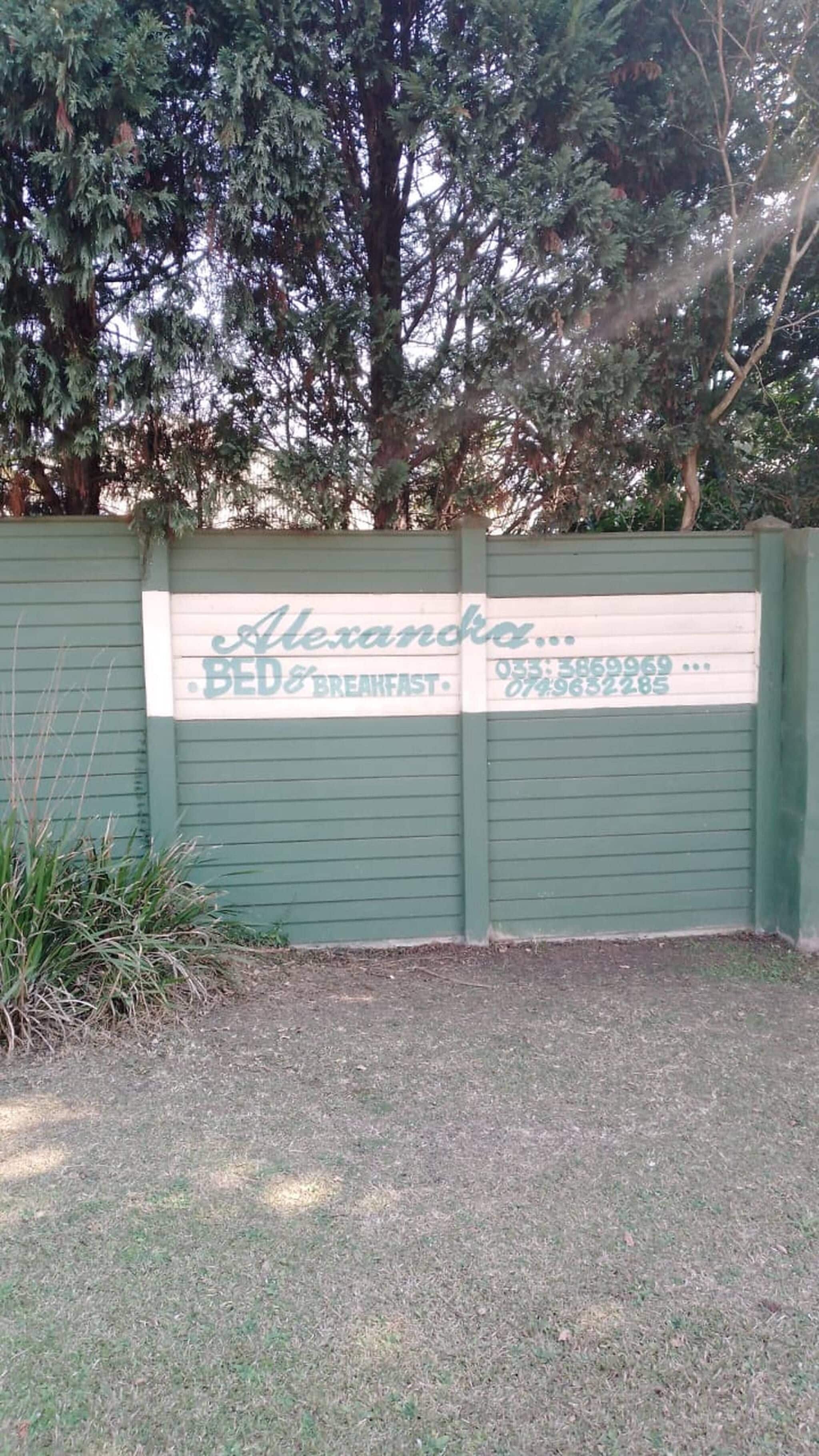 Ein grünes Tor mit einem Schild für 'Alexandra Bed & Breakfast', inklusive Telefonnummer.