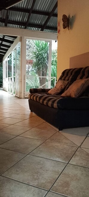 Una habitación con sofá, decoración de mariposa y vistas al exterior.