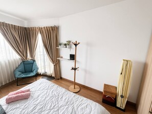 A modern bedroom with a bed, a chair, a coat rack, and a wardrobe. - Stylish Bangkok Escape Pool Gym & City Views (Bangkok)