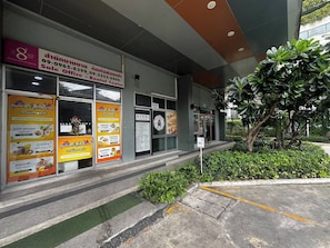 A commercial building with multiple storefronts, including a rental office and food centers. - Stylish Bangkok Escape Pool Gym & City Views (Bangkok)