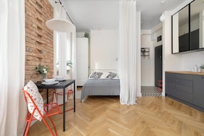 Ein modernes Schlafzimmer mit einem Bett, Nachttischen, einem Schreibtisch und einem Stuhl.