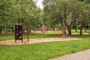 Ein Spielplatz mit verschiedenen Spielgeräten und einem Feldweg.