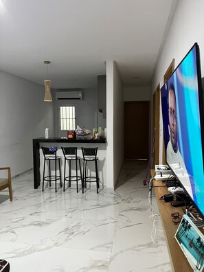 Eine moderne Küche mit Essbereich, einem Flachbildfernseher und einer Gaming-Station.