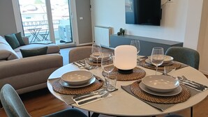 A dining area with a round table set for four, equipped with plates, cutlery, and glasses. - [Padova] Attico Deluxe 150 mq - Nuovo 2025 (Padova)