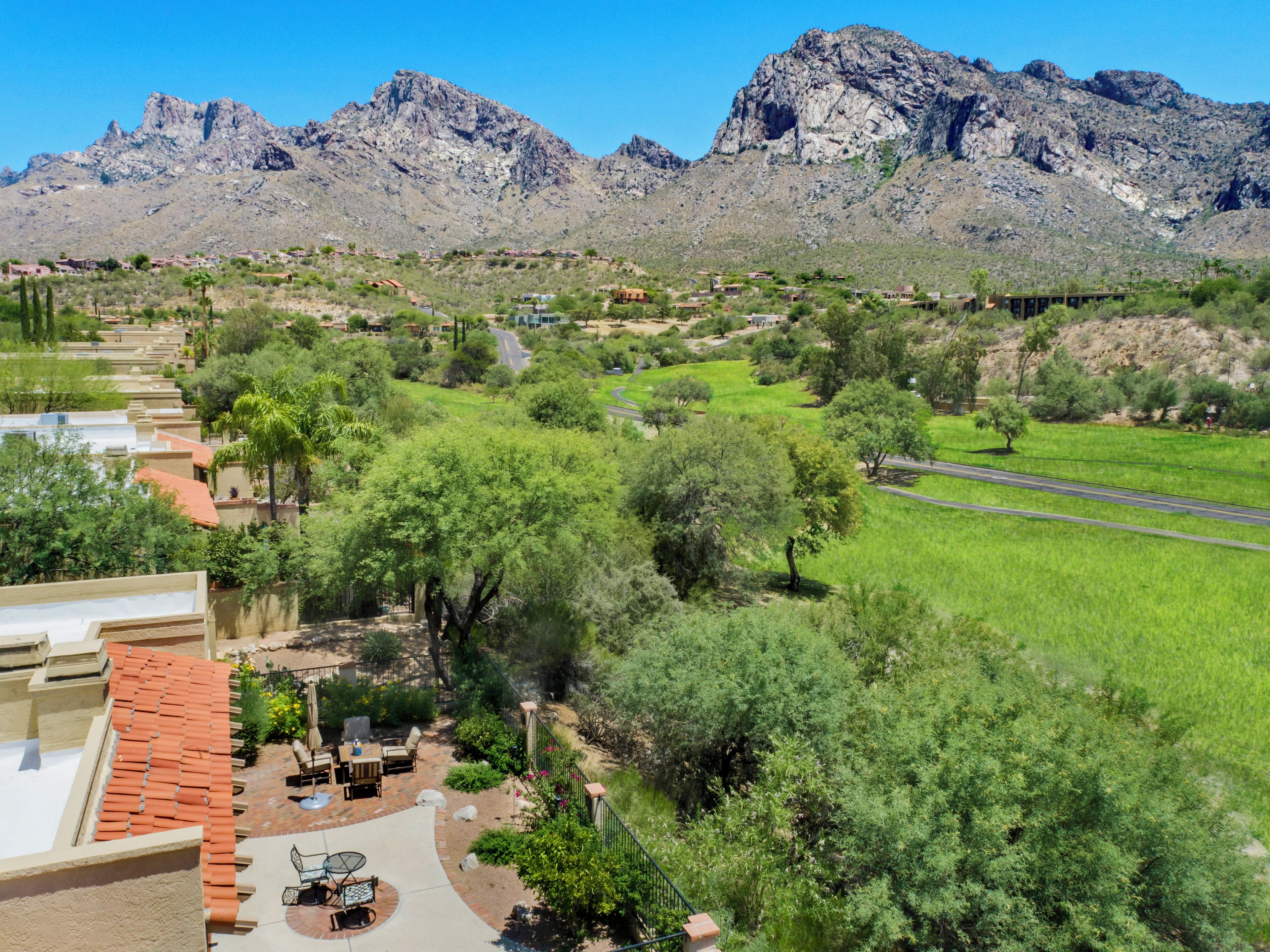 Zona residencial con patio, vistas a montañas y una carretera.