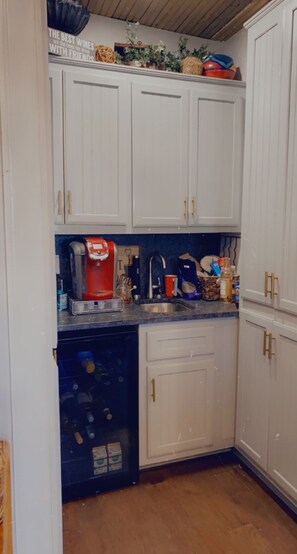 A kitchen with white cabinets, a coffee machine, and various kitchen items.