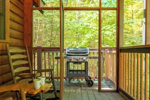A wooden deck with a grill and a table with chairs. - Country Bear Cove: Cozy Pigeon Forge Cabin with Hot Tub & Game Room (Pigeon Forge)