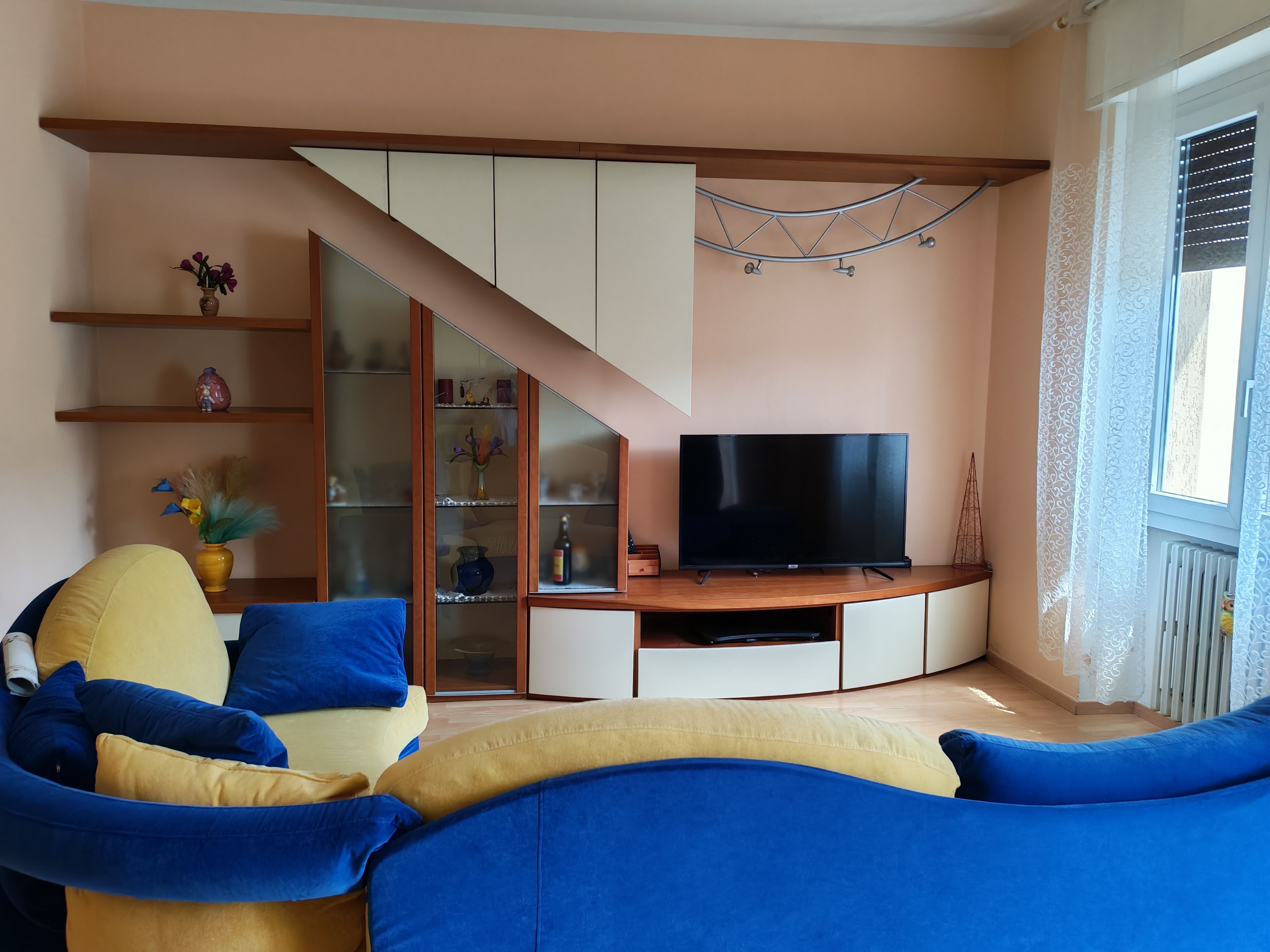 Un salon avec un canapé, une télévision et un escalier.