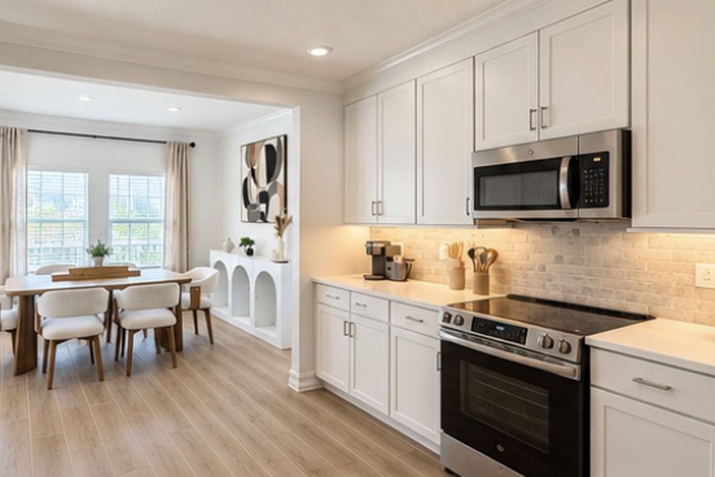 A modern kitchen with white cabinetry, a stainless steel microwave, and a black stove.