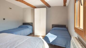 Una habitación con dos camas, un armario y una ventana.
