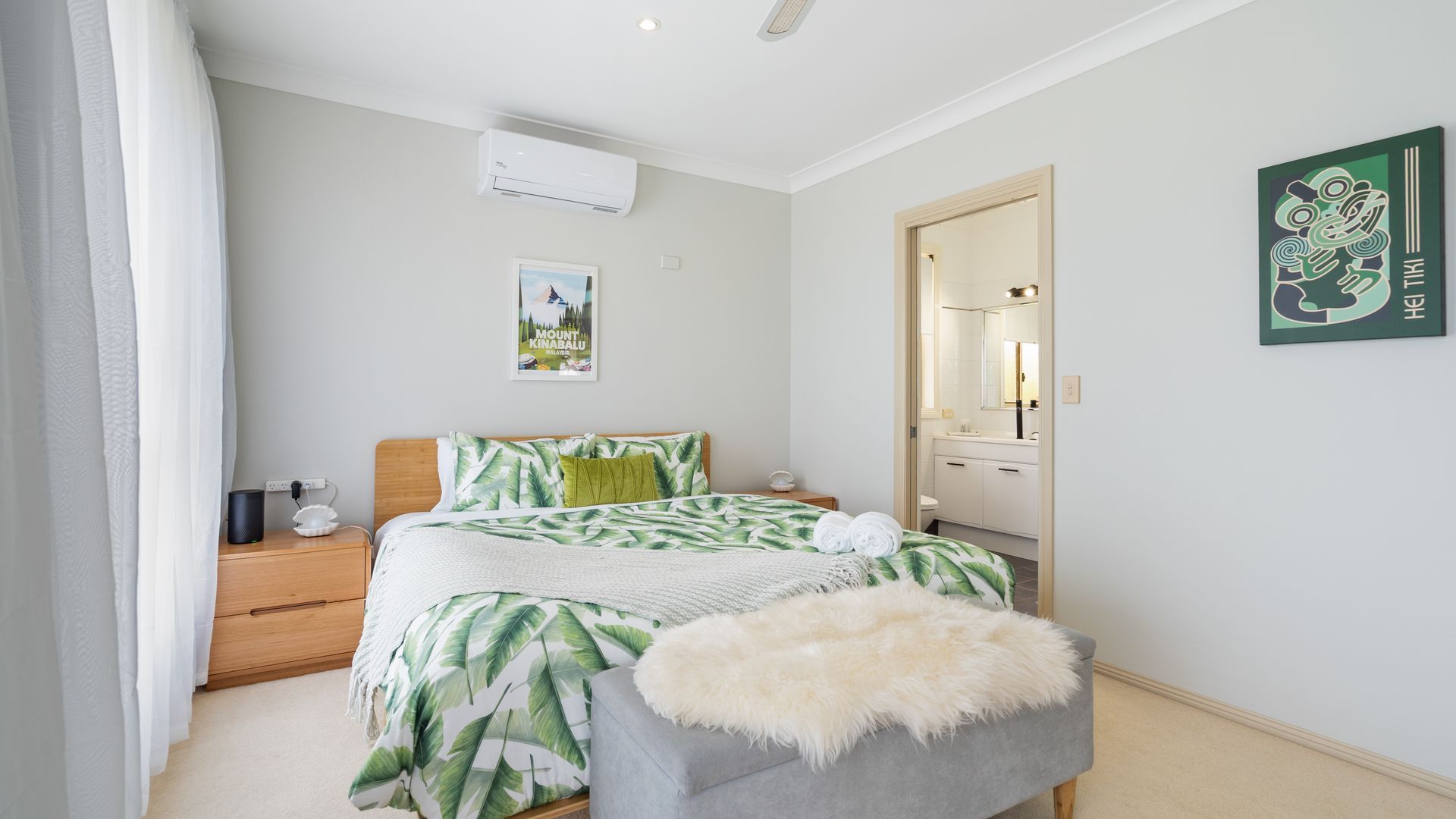 A bedroom with a bed, nightstand, and a wall-mounted air conditioner.