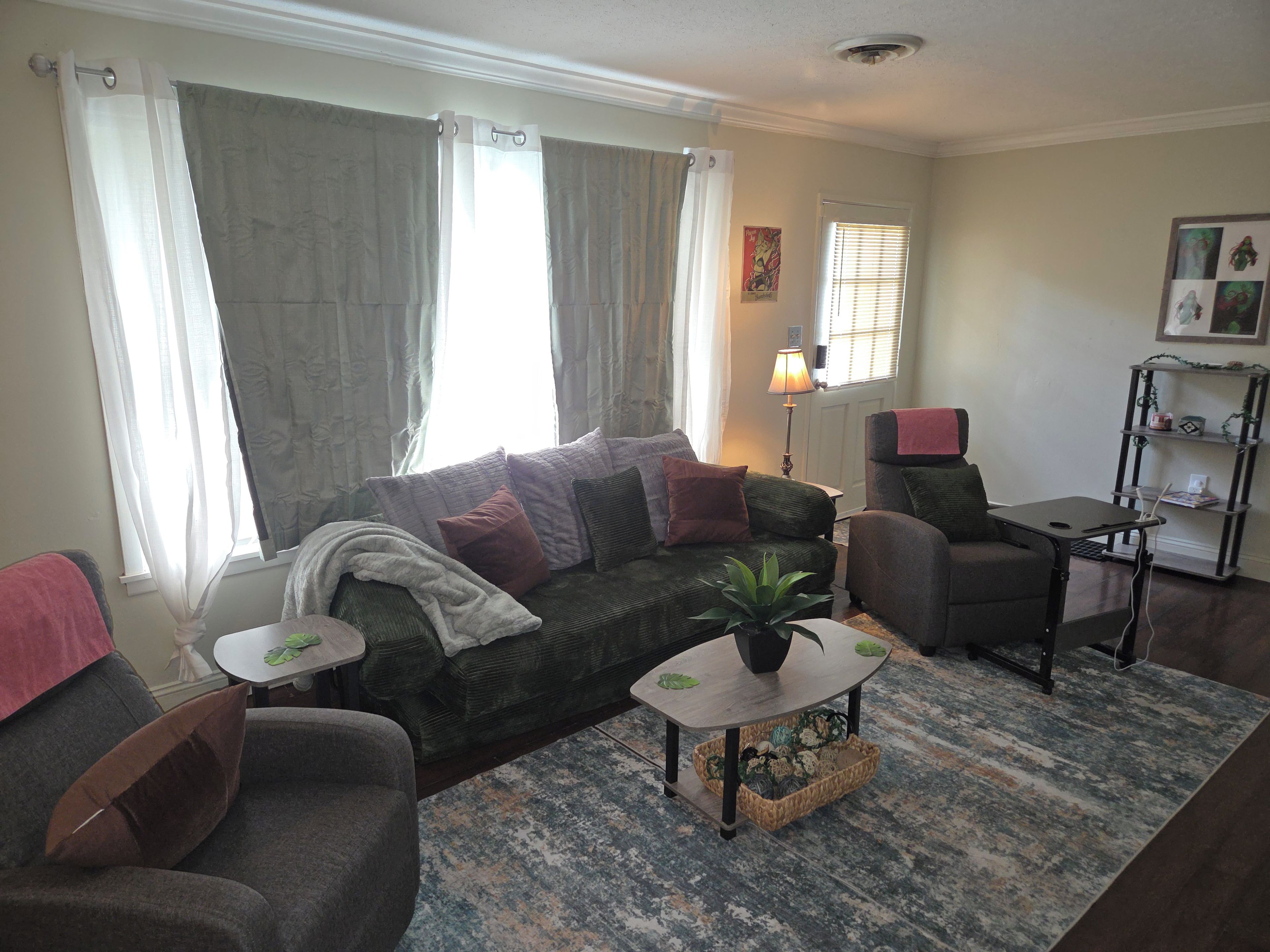 A living room with a sofa, armchair, coffee table, and a small side table.