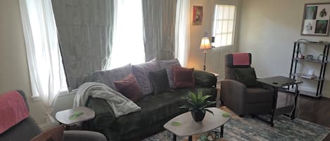 A living room with a sofa, armchair, coffee table, and a small side table.