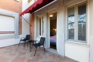 A room with a bed, a window, and a red awning.