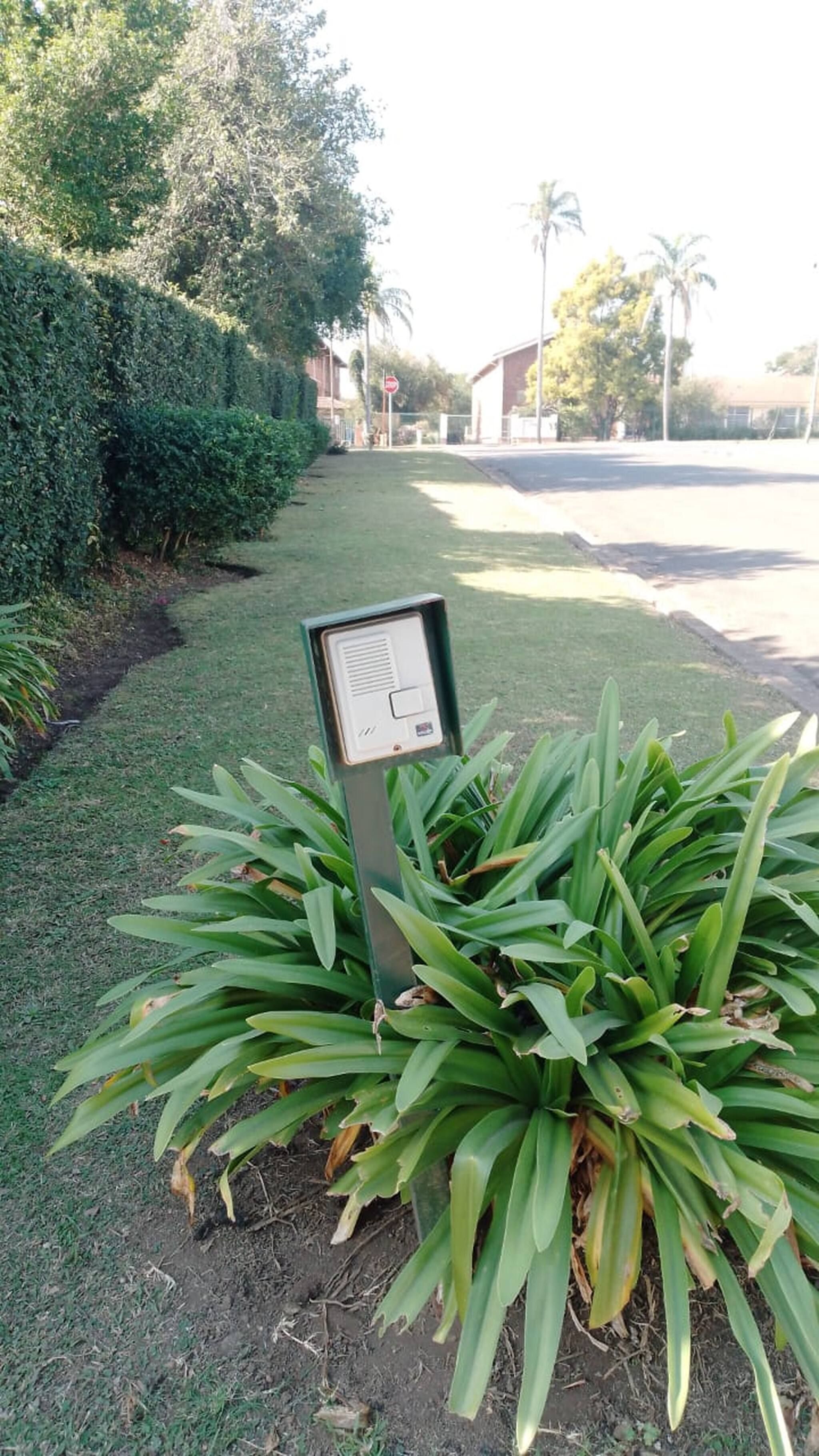 A signpost in a landscaped area with a road in the background.