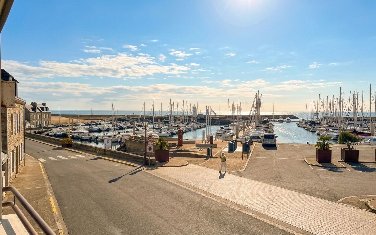 Een jachthaven met aan de wal afgemeerde boten, een heldere lucht en een weg die naar de jachthaven leidt.