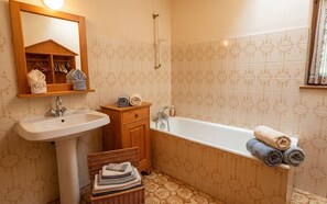 Un baño con lavabo, tocador y bañera.