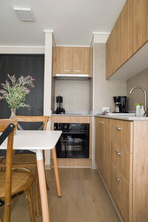A modern kitchen with wooden cabinets, a built-in oven, and a coffee maker. - Sleek Santiago Retreat City Views for 3 (Santiago)