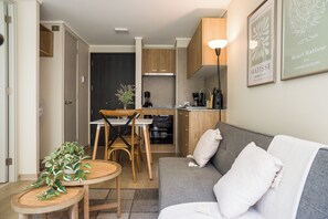 A compact living space with a kitchenette, a dining area, and a seating area with a sofa and a table. - Sleek Santiago Retreat City Views for 3 (Santiago)